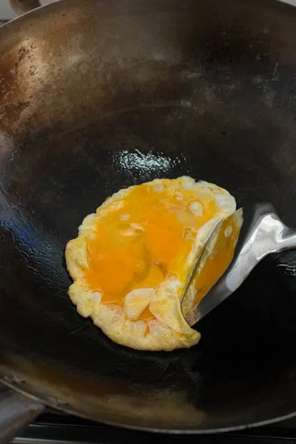 lightly beaten eggs in a wok