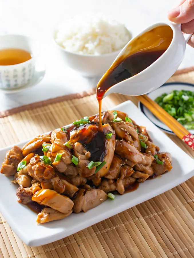 pouring teriyaki sauce on chicken