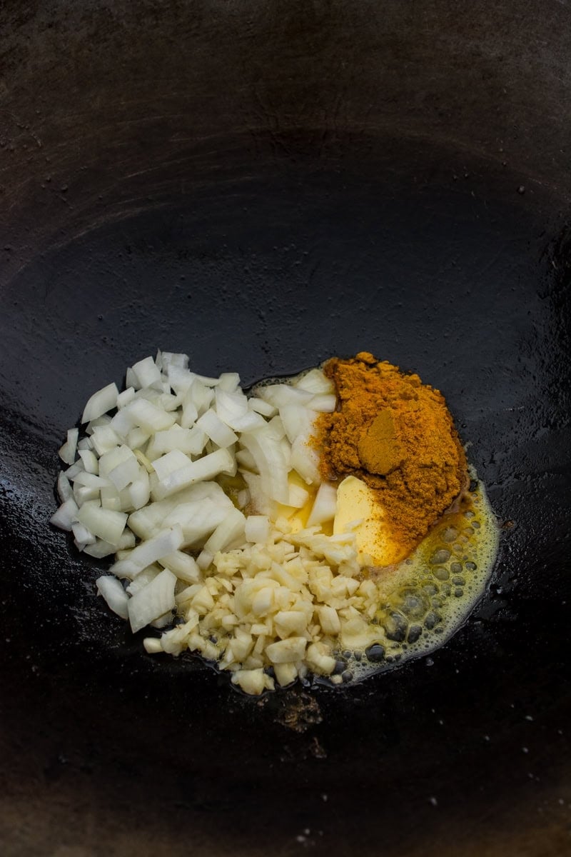 spices and aromatics in a wok for pineapple fried rice