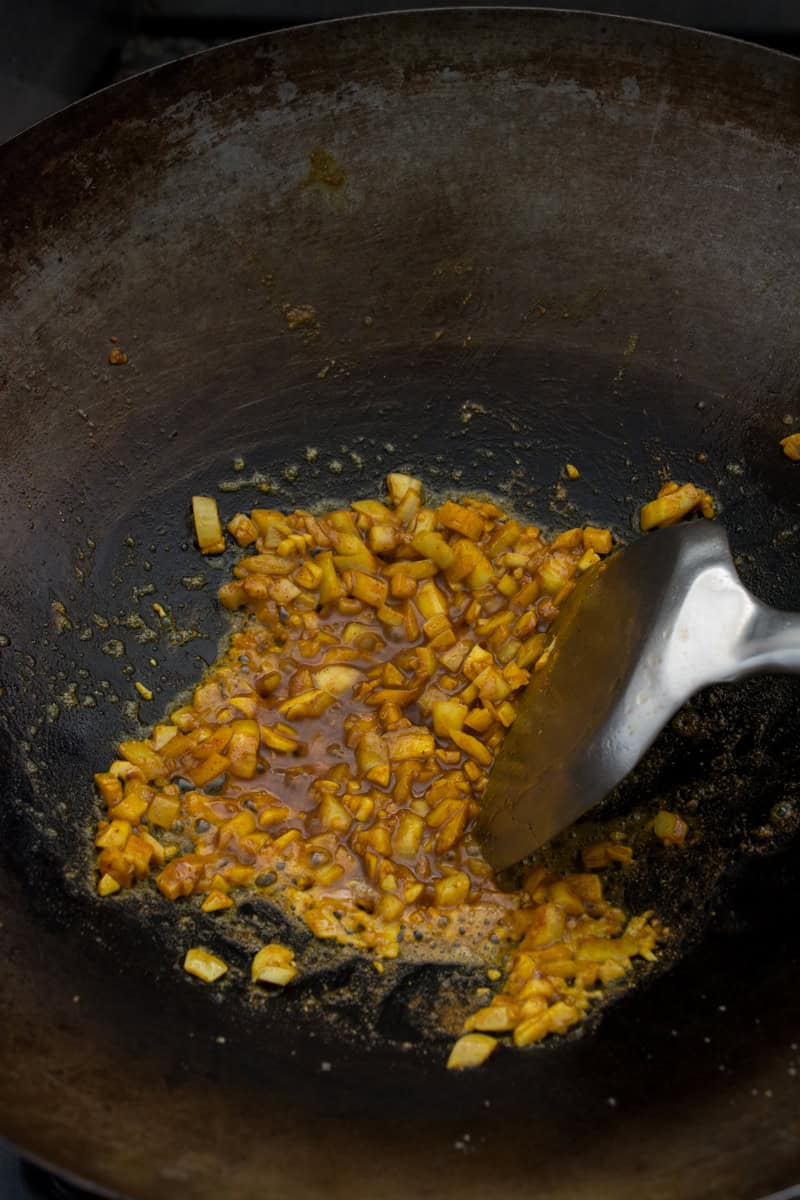 stir frying aromatics in a wok for pineapple fried rice