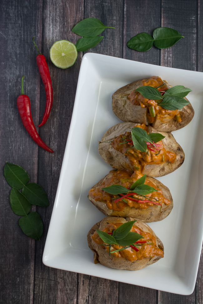 Thai Red Curry Baked Potatoes is an "East Meets West" version of comfort food. Perfect fluffy baked potato topped with a creamy, rich Thai Red Curry with tender chicken and crunchy green beans. 