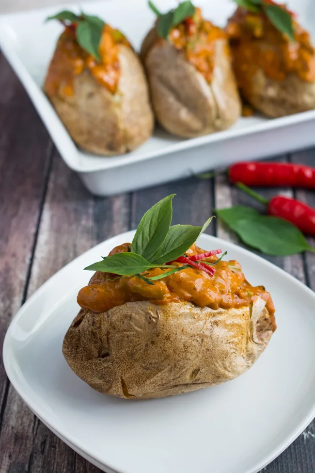 Thai Red Curry Baked Potatoes is an "East Meets West" version of comfort food. Perfect fluffy baked potato topped with a creamy, rich Thai Red Curry with tender chicken and crunchy green beans. 