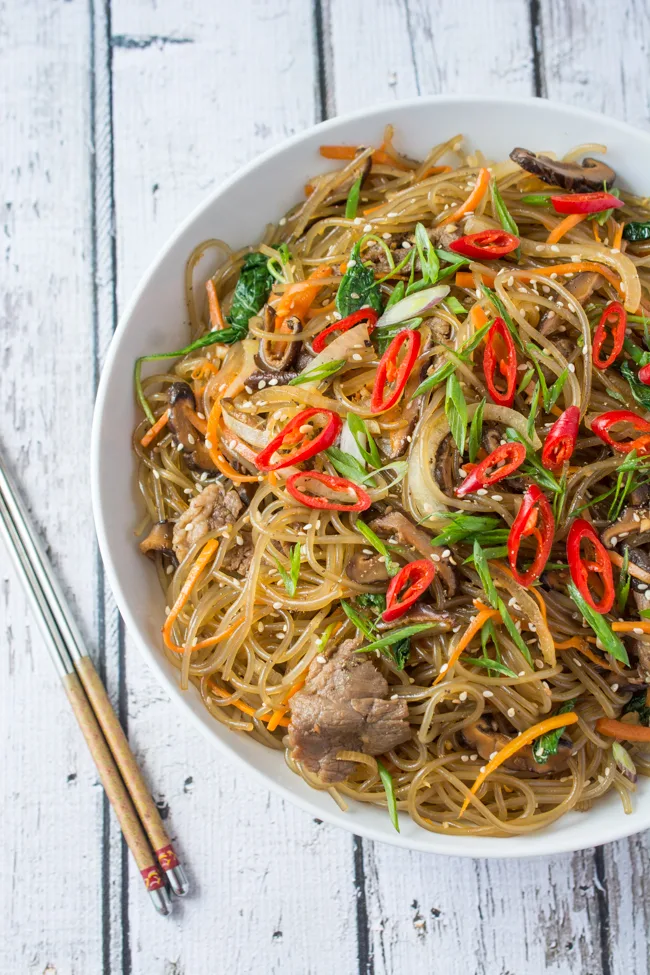 Japchae is a classic Korean noodle dish that can be served as a side dish, main dish, or over rice. Stir-fried glass noodles with sliced beef, julienned carrots, vegetables and mushrooms, tossed in a sweet soy sauce dressing.