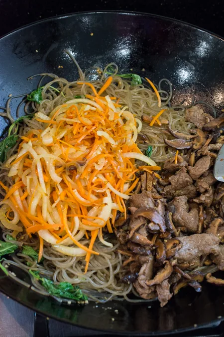 Japchae is a classic Korean noodle dish that can be served as a side dish, main dish, or over rice. Stir-fried glass noodles with sliced beef, julienned carrots, vegetables and mushrooms, tossed in a sweet soy sauce dressing.