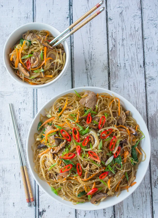 Japchae is a classic Korean noodle dish that can be served as a side dish, main dish, or over rice. Stir-fried glass noodles with sliced beef, julienned carrots, vegetables and mushrooms, tossed in a sweet soy sauce dressing.