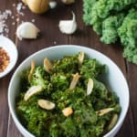 These healthy Spicy Garlic Kale Chips are irresistibly crispy and tasty! Fresh kale leaves are tossed in garlic oil and garlic powder, baked till crisp, then topped with crunchy garlic chips and spicy crushed red pepper.