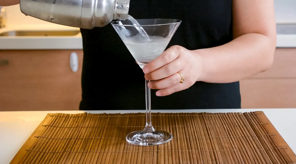 pouring lychee martini into glass