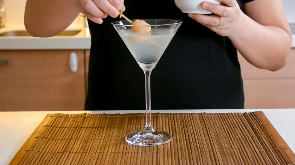 garnishing lychee martini with fresh lychee