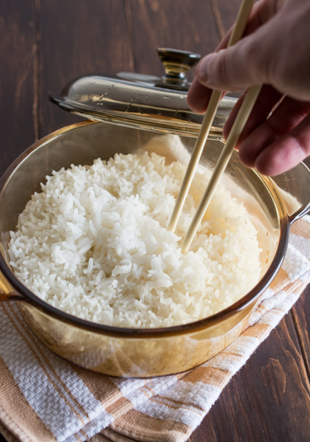 fluffing up rice with a pair of chopsticks