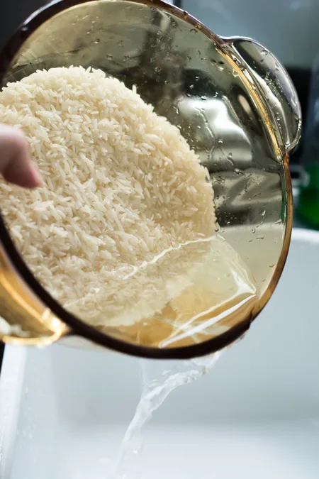 Pouring water out of pot after rinsing. 