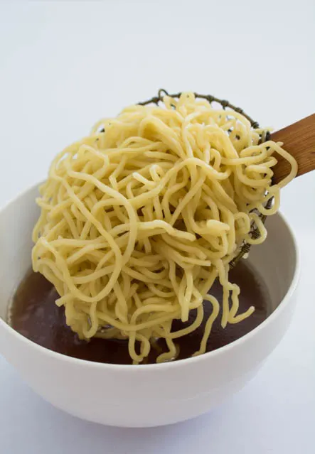 Traditional Shoyu Ramen features a savory soy-sauce based clear broth and ramen noodles with classic toppings such as chashu, seasoned bamboo shoots, and a half-boiled seasoned egg.