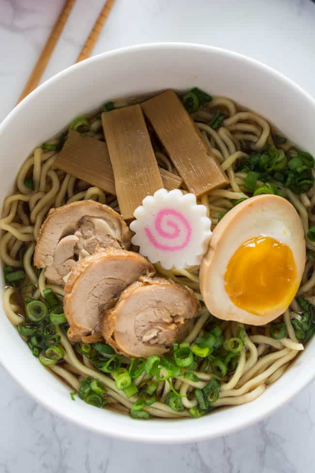 Traditional Shoyu Ramen features a savory soy-sauce based clear broth and ramen noodles with classic toppings such as chashu, seasoned bamboo shoots, and a half-boiled seasoned egg.