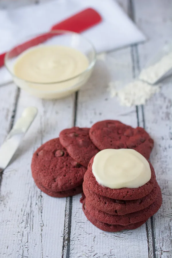 These Red Velvet Chocolate Chip Cookies are awesome enough on their own, but add the Cream Cheese Frosting and it takes the cookie to a whole new level of YUM!