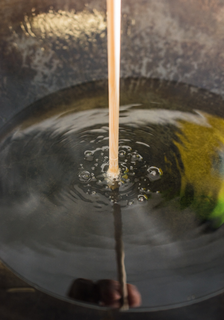 testing hot oil with wooden chopstick