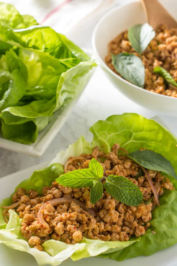 pork thai larb in lettuce wrap white background