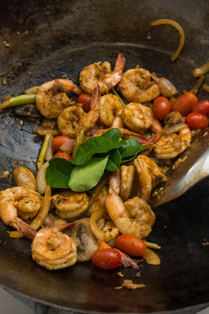 stir fried tom yum shrimp with kafir lime leaves in wok