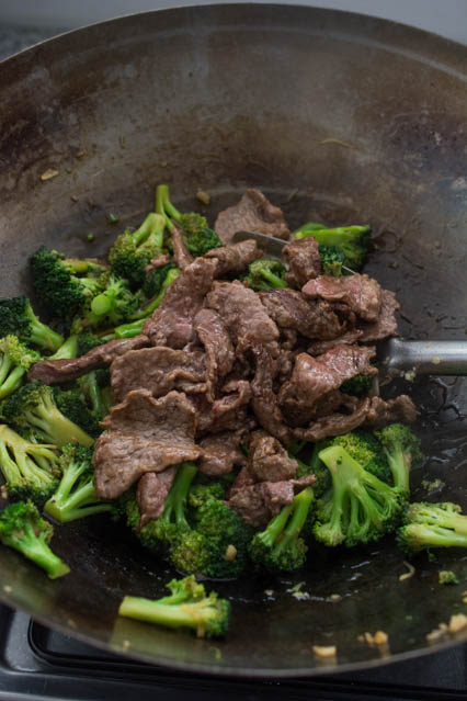 beef and broccoli in a wok being stir fried