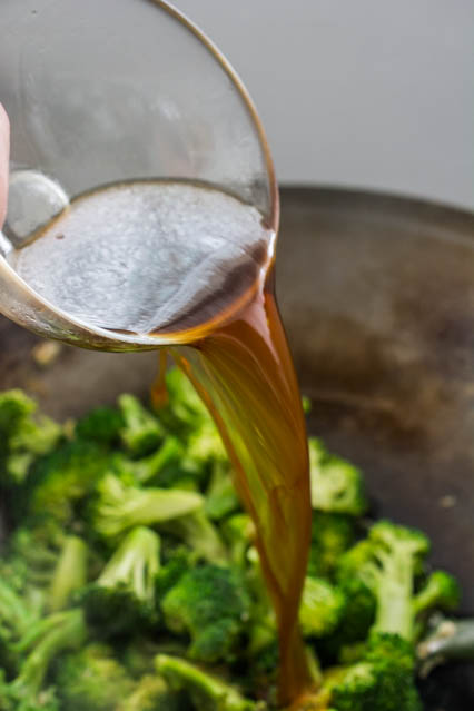 pouring the sauce in the wok for beef and broccoli