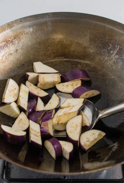 stir frying eggplant in a wok