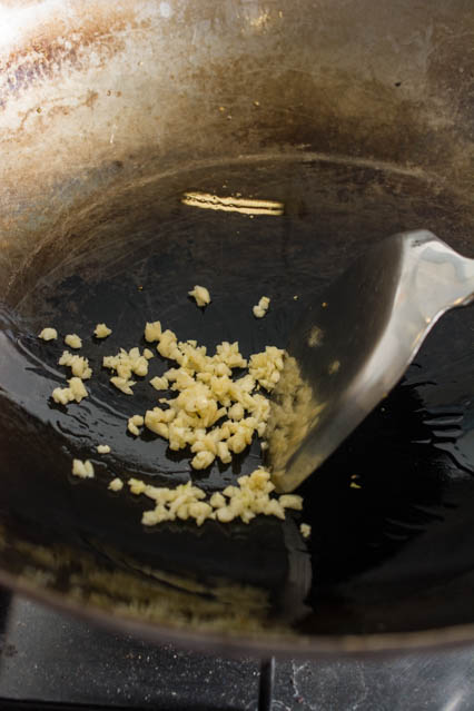 frying minced garlic in a wok