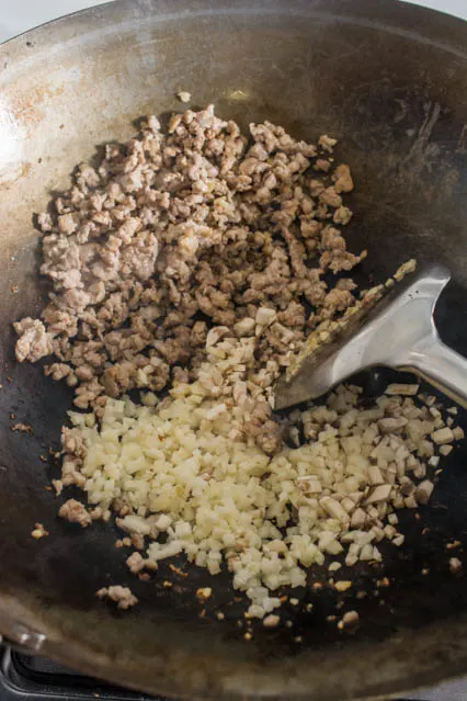 ground pork and diced water chestnuts in a wok