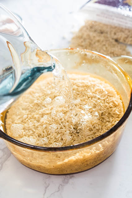 pouring water on brown rice