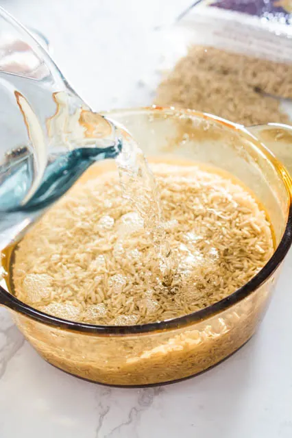 pouring water on brown rice