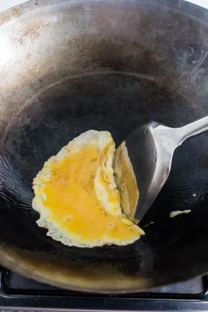 fried beaten egg in a wok for pad woon sen