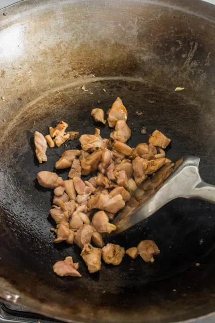 diced chicken thigh in a wok for pad woon sen