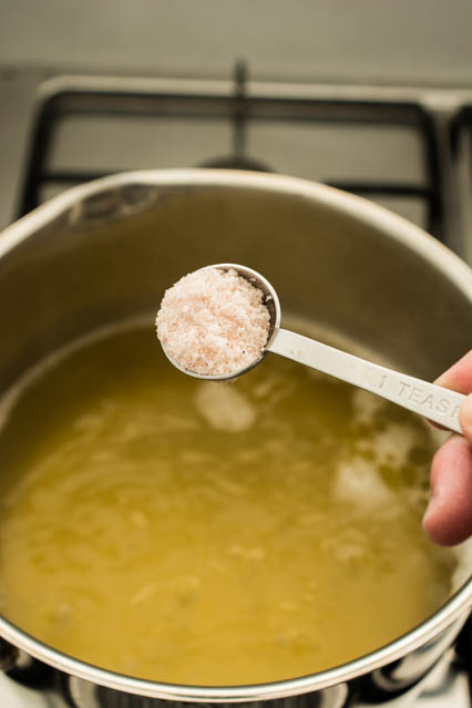 pouring salt into chicken stock for egg drop soup