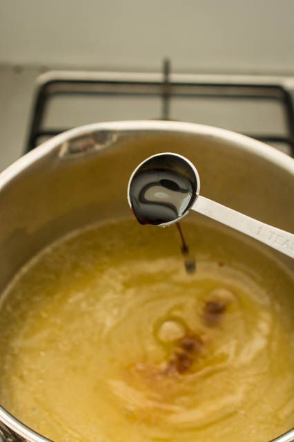 pouring soy sauce into chicken stock for egg drop soup