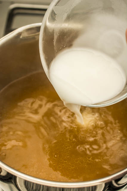 pouring cornstarch into egg drop soup