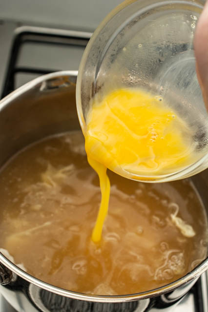 pouring egg into egg drop soup