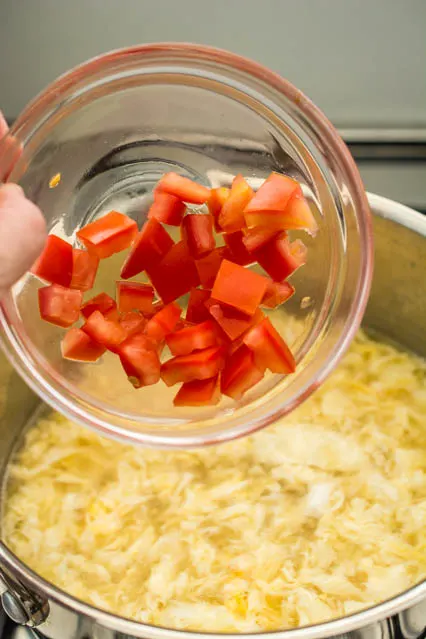 adding diced tomato to egg drop soup
