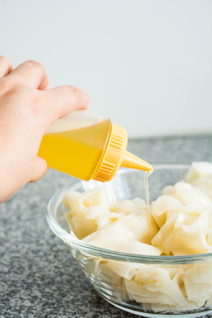 pouring oil over rice noodles