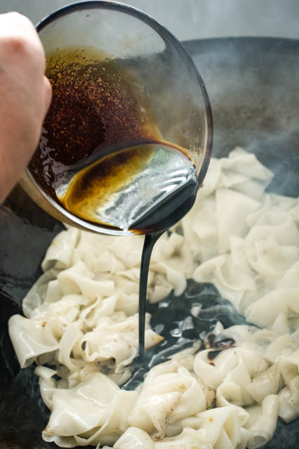 pouring pad see ew sauce on noodles