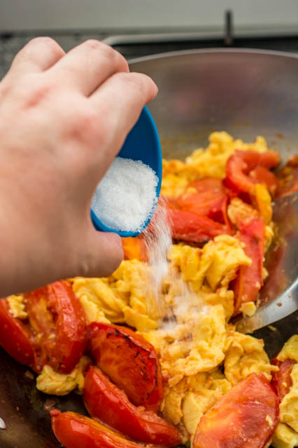 pouring sugar over chinese tomato and egg