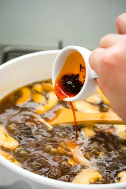 adding chili oil to hot and sour soup