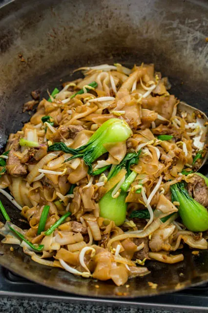 stir fried beef chow fun in a wok