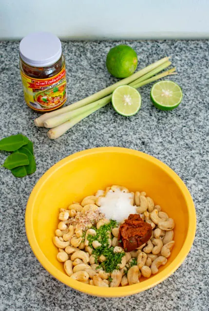 raw cashew nuts with thai tom yum paste in a bowl