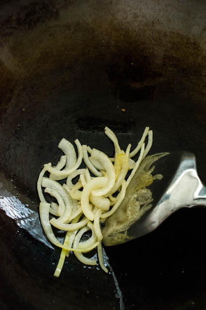 saute sliced onion in wok for nasi lemak sambal
