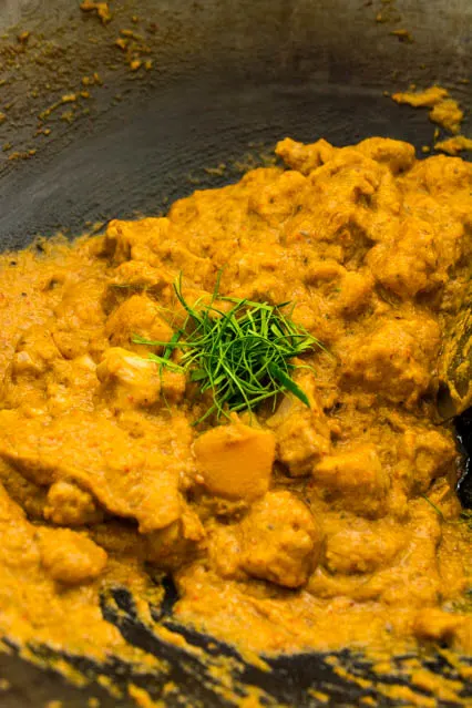 adding kaffir lime leaves to red curry