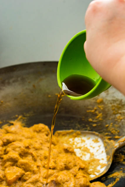 pouring fish sauce into red curry