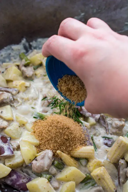 pouring brown sugar into thai green curry