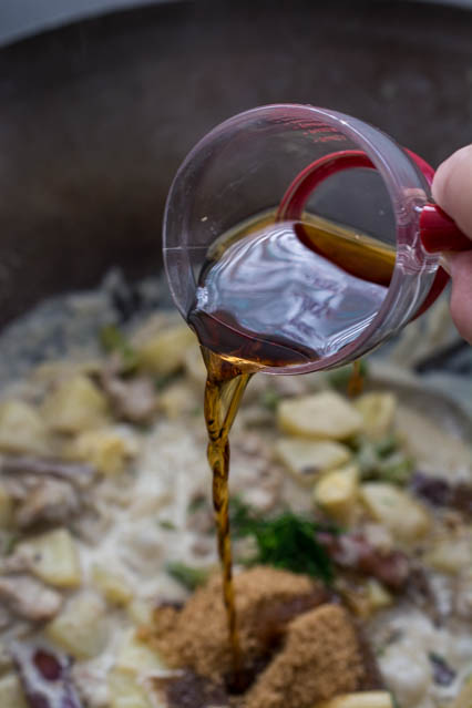 pouring fish sauce into Thai green curry