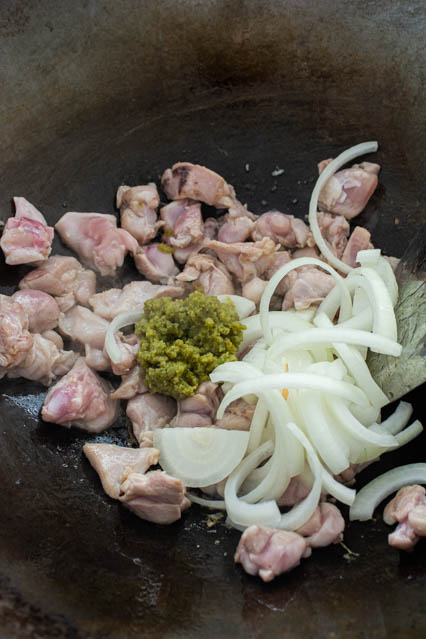 chicken, onion and green curry paste in wok
