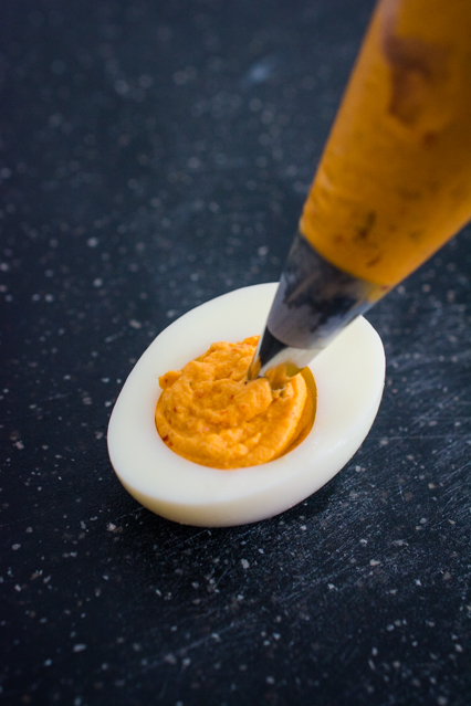 piping deviled egg yolk mixture to hard boiled egg white