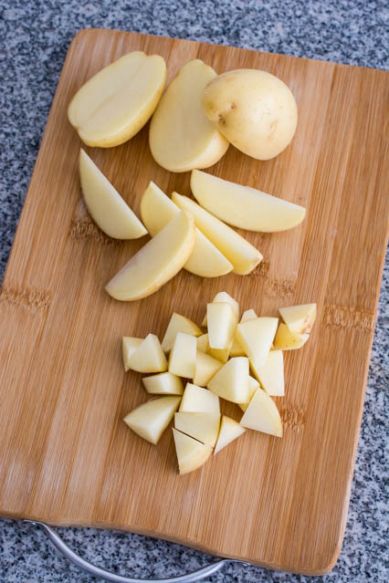 cut potatoes on a bamboo cutting board