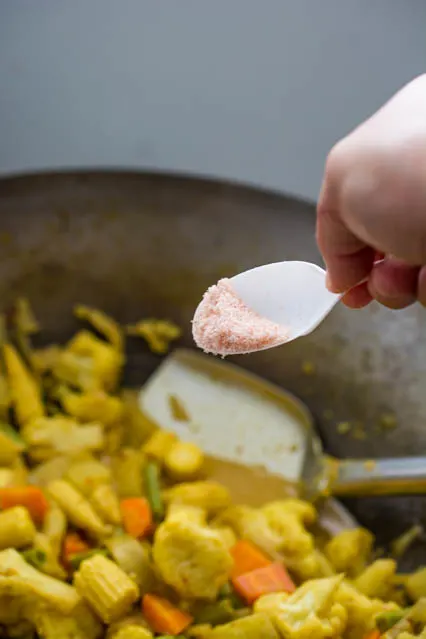 pouring salt over vegetables