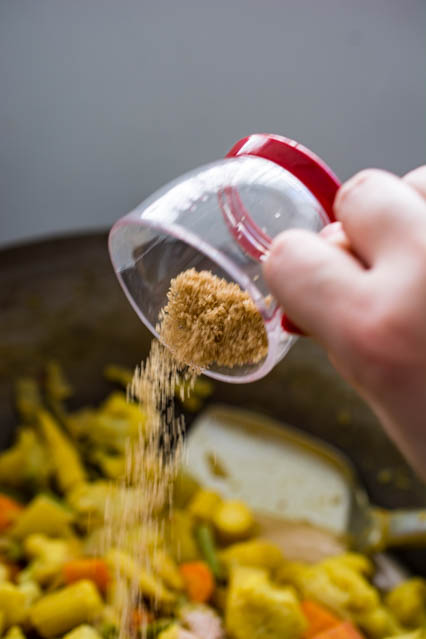 pouring brown sugar over vegetables
